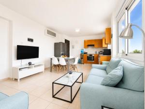 a living room with a blue couch and a table at Pantelia Apartment Paralimni in Paralimni