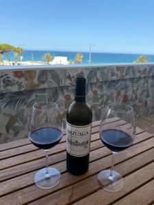 a bottle of wine and two glasses on a wooden table at Espejo del mar in Mojácar