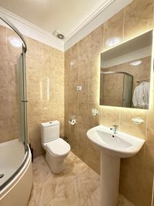 a bathroom with a toilet and a sink and a mirror at Alex Hotel in Odesa +63 photos
