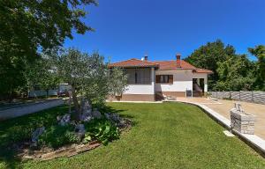 a house with a yard with a tree in it at Apartment Modrusani 1561 in Žminj