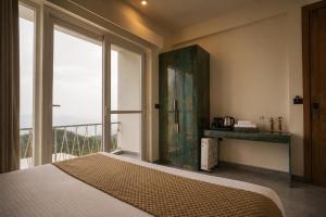 a bedroom with a bed and a large window at Anuttara Retreat in Narendranagar