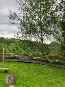 a hammock tied to a fence with a tree at Przystanek 470 in Krościenko