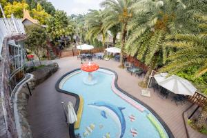 an indoor swimming pool with an umbrella and a wave at Guilin Thai Impression in Gukeng