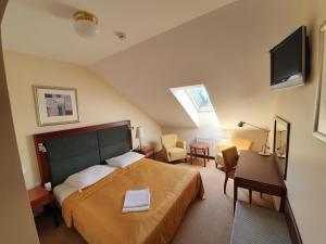 a bedroom with a bed and a television and a chair at Dwór Zielone Wzgórza in Bukowno