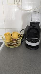 a coffee maker with a basket and two coffee cups at Gaviotas piscina comunitaria in Calafat