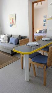 a living room with a table and a couch at Gaviotas piscina comunitaria in Calafat +8 photos