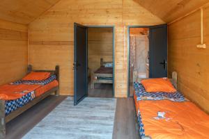two beds in a room with wooden walls at Noygut in Dzhetyoguz