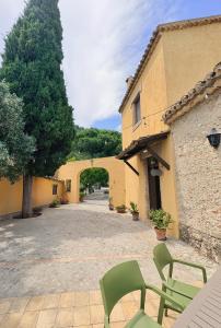 a patio with two green chairs and a building at Azienda Agrituristica Le Puzelle in Santa Severina