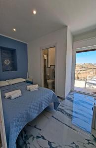 a bedroom with a bed and a large window at Agrigento Zefiro Rooms in Agrigento