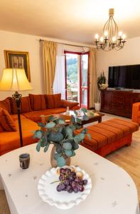 a living room with orange furniture and a vase of grapes on a table at Apartmány Sonáta Luhačovice in Luhačovice