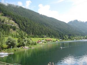 a lake with a boat in the middle of a mountain at Haus Serena in Sonnenalpe Nassfeld