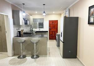 a large kitchen with a counter and stools in it at Sofies's Apartments in Lusaka