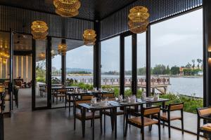 a restaurant with tables and chairs with a view of the water at Amber Kampot in Kampot