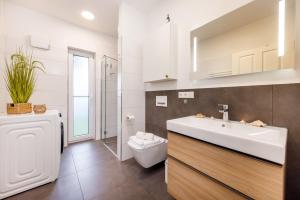 a bathroom with a white sink and a toilet at FeWo Lieblingsplatz in Zingst