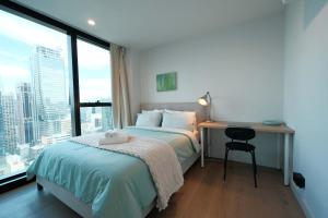 a bedroom with a bed and a desk with a window at Premium 3BR CBD Apt Prime Location in Melbourne