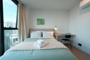 a bedroom with a bed with a stuffed animal on it at Premium 3BR CBD Apt Prime Location in Melbourne