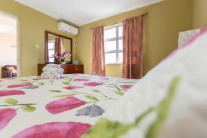 1 dormitorio con 1 cama con colcha de flores en The Dorchester, en Kingston