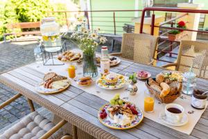 a wooden table with breakfast foods and drinks on it at Apartmány Sonáta Luhačovice in Luhačovice