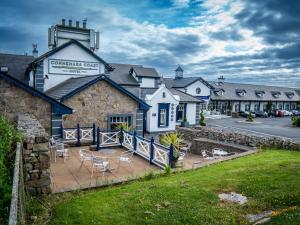 a hotel with chairs and tables in front of a building at Connemara Coast Hotel in Furbo