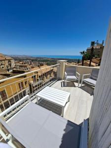 a balcony with a table and chairs and the ocean at Agrigento Zefiro Rooms in Agrigento
