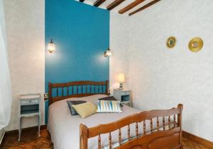 a bedroom with a bed with a blue wall at Gîte du Gros Hêtre in Sainte-Beuve-en-Rivière