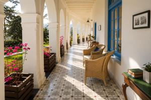 a hallway of a house with chairs and flowers at Pine Retreat - A Premium Heritage Property in Mussoorie