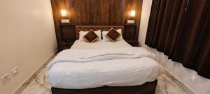 a bed with white sheets and pillows in a room at ANG'S Retreat By WINGS Expolores in Gangtok