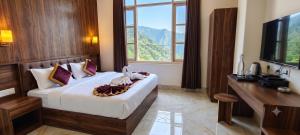 a bedroom with a bed with a television and a window at ANG'S Retreat By WINGS Expolores in Gangtok