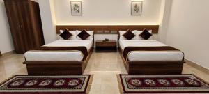 two beds in a room with two rugs at ANG'S Retreat By WINGS Expolores in Gangtok