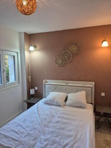 a bedroom with a bed with two pillows on it at Partie de ferme appartement in Paluds de Noves
