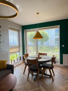a dining room with a table and chairs and a couch at Apartament Krisa z ogródkiem in Pogórze