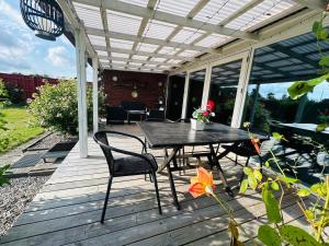 a patio with a table and chairs on a deck at Cozy Home - Holiday, Sleepover in Rødbyhavn