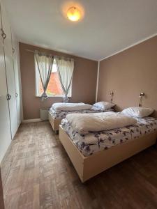 a bedroom with two beds and a window at Cozy Home - Holiday, Sleepover in Rødbyhavn