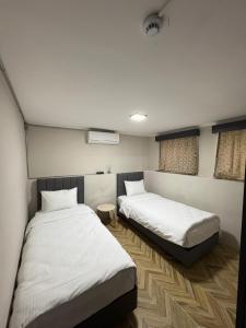 two beds in a room with white sheets at Avlia Konakları in Edirne