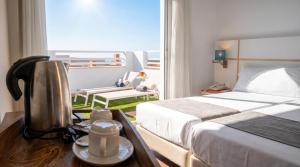 a hotel room with a bed and a coffee pot on a table at Hotel Vértice Chipiona Mar in Chipiona +48 photos