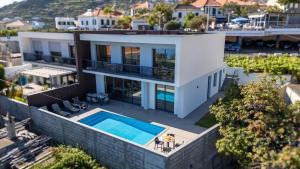 an aerial view of a house with a swimming pool at Evoque Villa by LovelyStay in Arco da Calheta