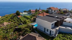 an aerial view of a house and the ocean at Evoque Villa by LovelyStay in Arco da Calheta