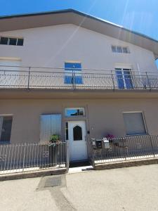 a white house with a white door and a balcony at "Nonna Maria" in Venegono Superiore