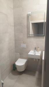 a bathroom with a white toilet and a sink at Apartament centrum-rynek Gorzów Wlkp. in Gorzów Wielkopolski