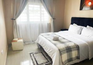 a bedroom with a large bed and a window at Sofies's Apartments in Lusaka