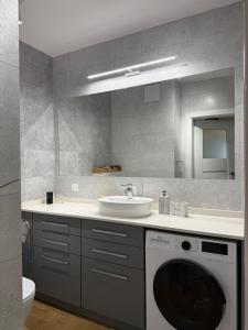 a bathroom with a washing machine and a sink at Apartament Krisa z ogródkiem in Pogórze