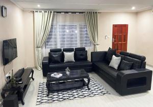 a living room with a black couch and a table at Sofies's Apartments in Lusaka