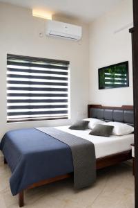 a bedroom with a large bed and a window at Sidra Apartments - Spacious 2BHK Family Stay in Nilgiris, Pandalur, Tamil Nadu in Pandalūr