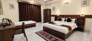 a hotel room with two beds and a desk at ANG'S Retreat By WINGS Expolores in Gangtok +26 photos
