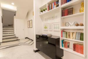 a home office with a black desk and bookshelves at Suite Home Milano Fiera in Milan