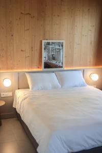 a bedroom with a white bed with wooden walls at Casa Brutarului in Timişoara