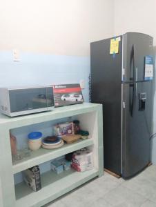 a kitchen with a refrigerator and a shelf with a microwave at Casa céntrica amplia en Veracruz in Veracruz