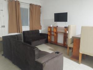 a living room with a couch and a television at Casa céntrica amplia en Veracruz in Veracruz