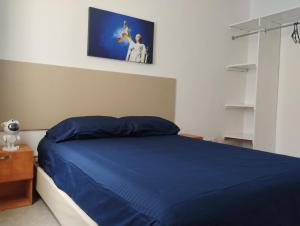 a bedroom with a blue bed with a picture on the wall at Casa céntrica amplia en Veracruz in Veracruz