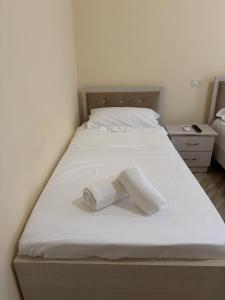 a white bed with two rolls of towels on it at Blue Shore in Golem